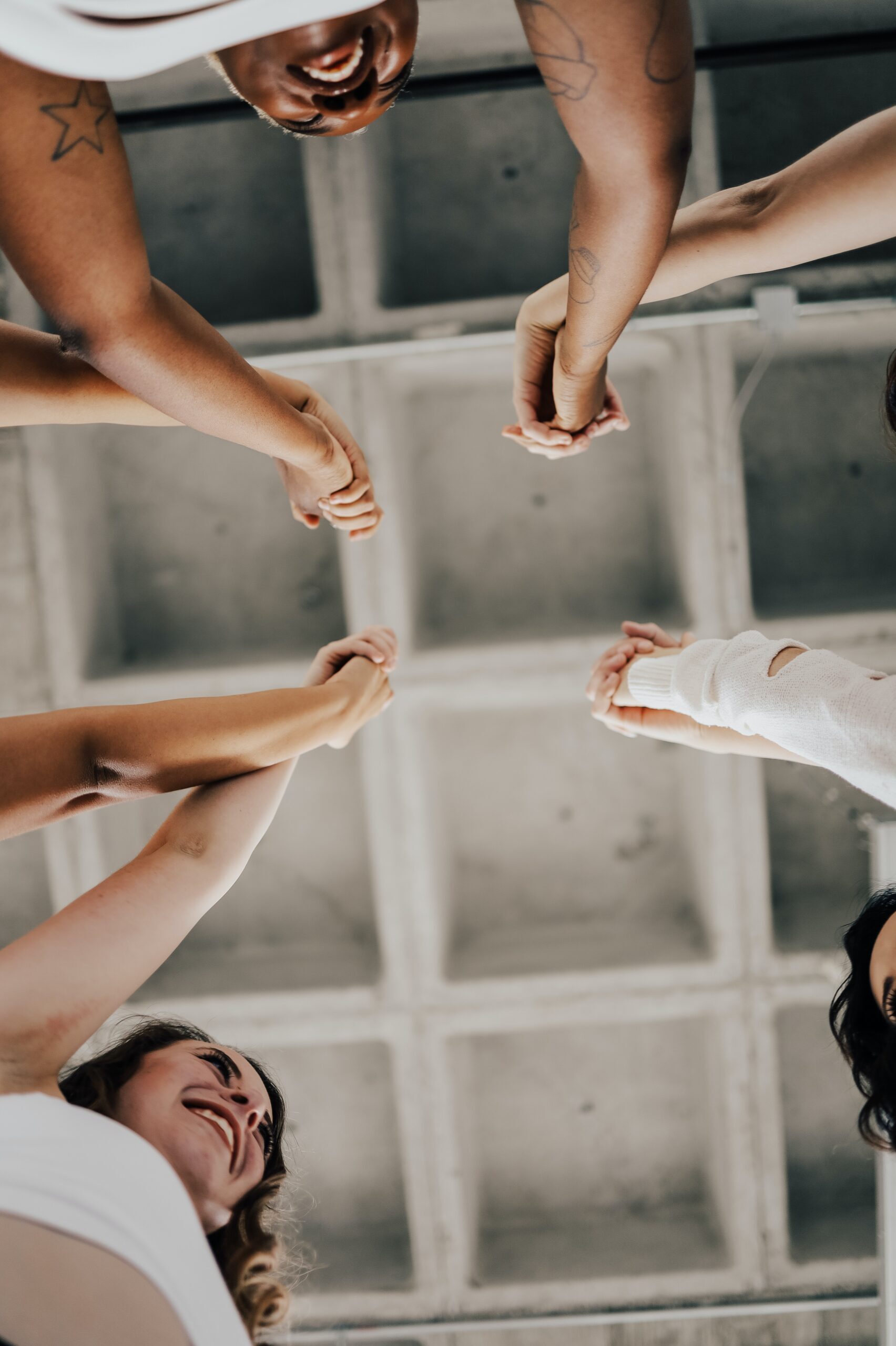 View of white ceiling, arms in the air, hands joined together, united and happy